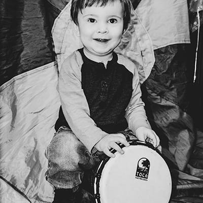 Glimlagende kind met tamboeryn